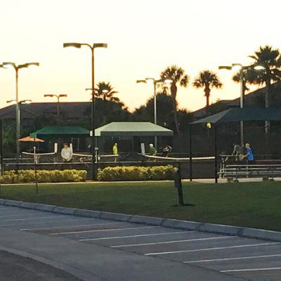 Teniszezés naplementekor nyolc teniszpályán